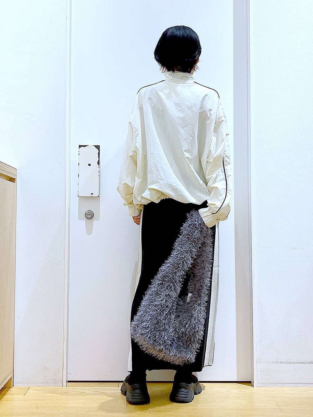 ブラック系のスカート、ベージュ系のブルゾン、グレー系のショルダーバッグを着用したレディースの秋コーディネートの5枚目の写真