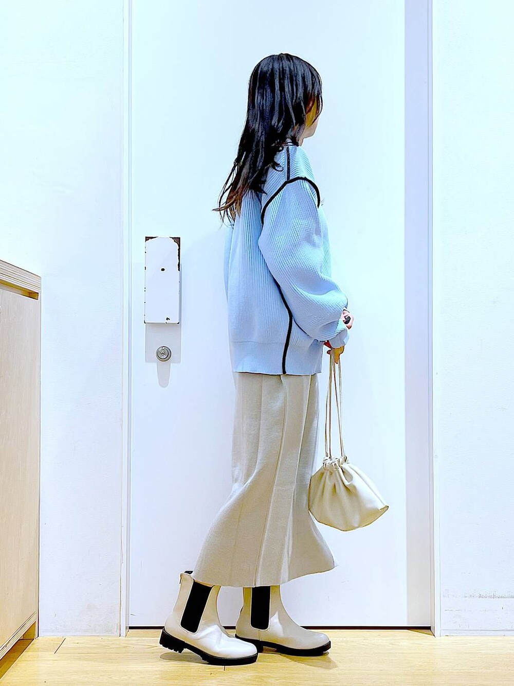 グレー系のスカート、その他のニット/セーター、ベージュ系のブーツを着用したレディースの春コーディネートの4枚目の写真