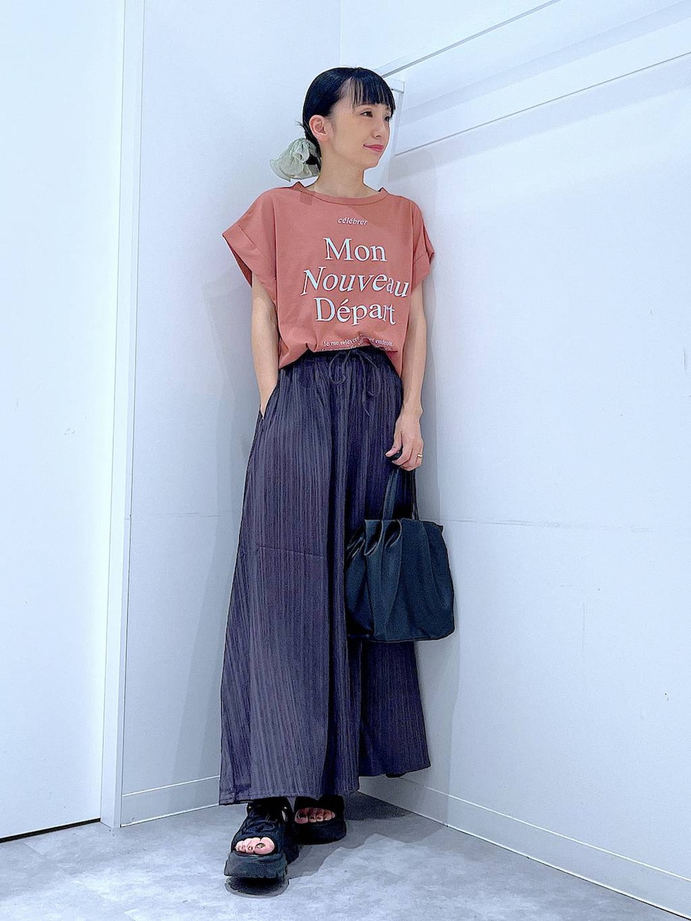 ブラウン系のTシャツ/カットソー、グレー系のその他パンツ、ブラック系のハンドバッグを着用したレディースの夏コーディネートの2枚目の写真