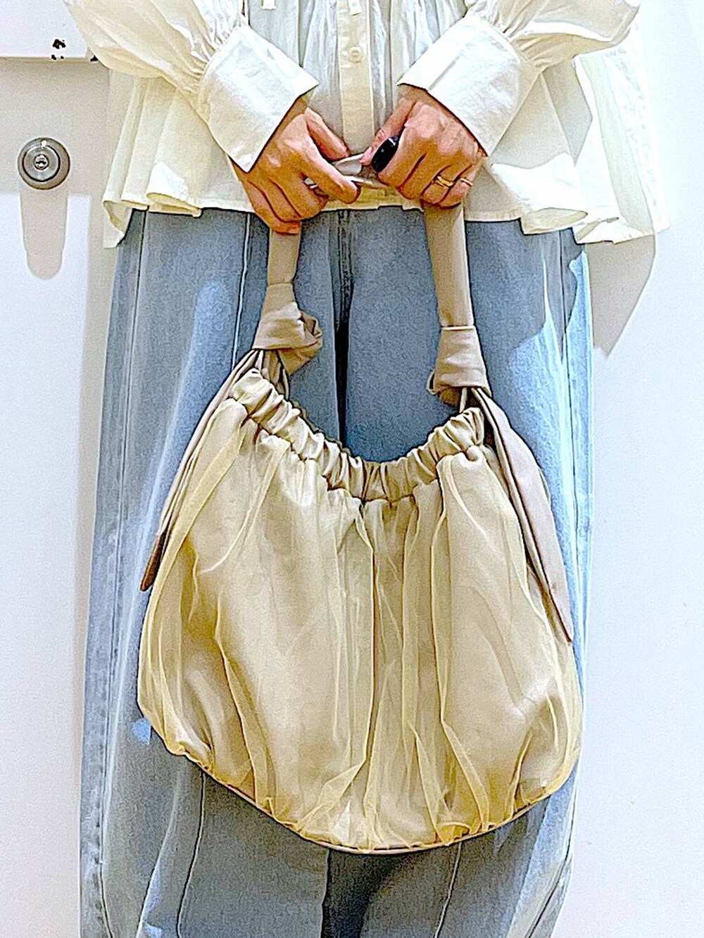 ベージュ系のトートバッグ、シルバー系のローファー、ホワイト系のシャツ/ブラウスを着用したレディースの秋コーディネートの9枚目の写真