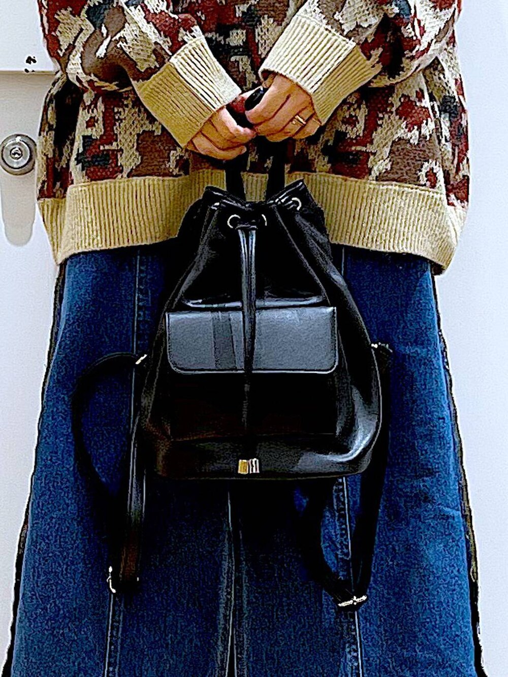 ブラック系のバックパック/リュック、ブルー系のデニムスカート、ブラック系のブーツを着用したレディースの冬コーディネートの9枚目の写真