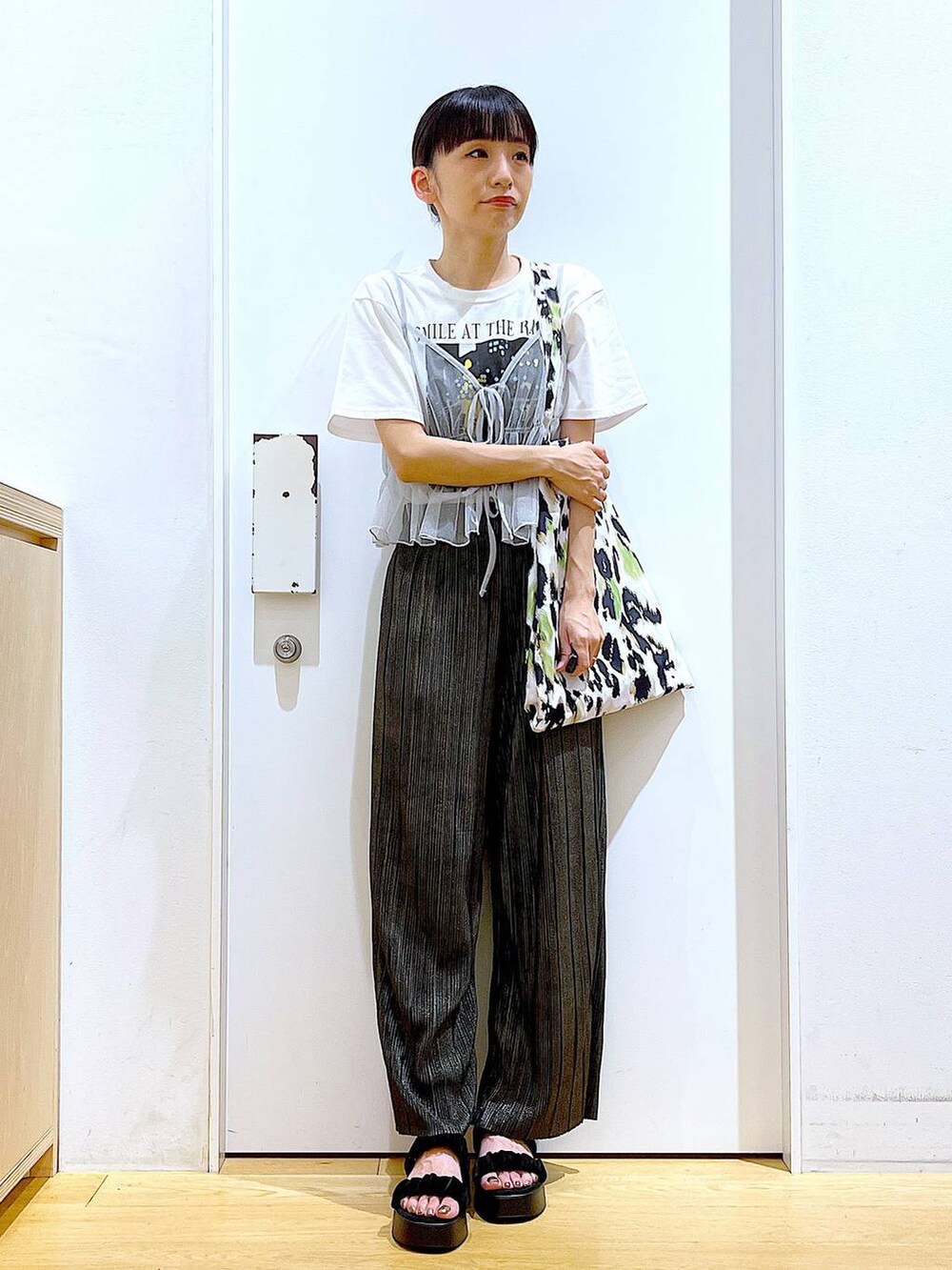 グリーン系のトートバッグ、シルバー系のキャミソール、ホワイト系のTシャツ/カットソーを着用したレディースの夏コーディネートの2枚目の写真