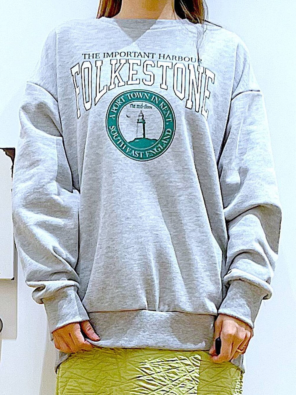 グリーン系のスカート、グレー系のスウェット、ホワイト系のショルダーバッグを着用したレディースの春コーディネートの7枚目の写真