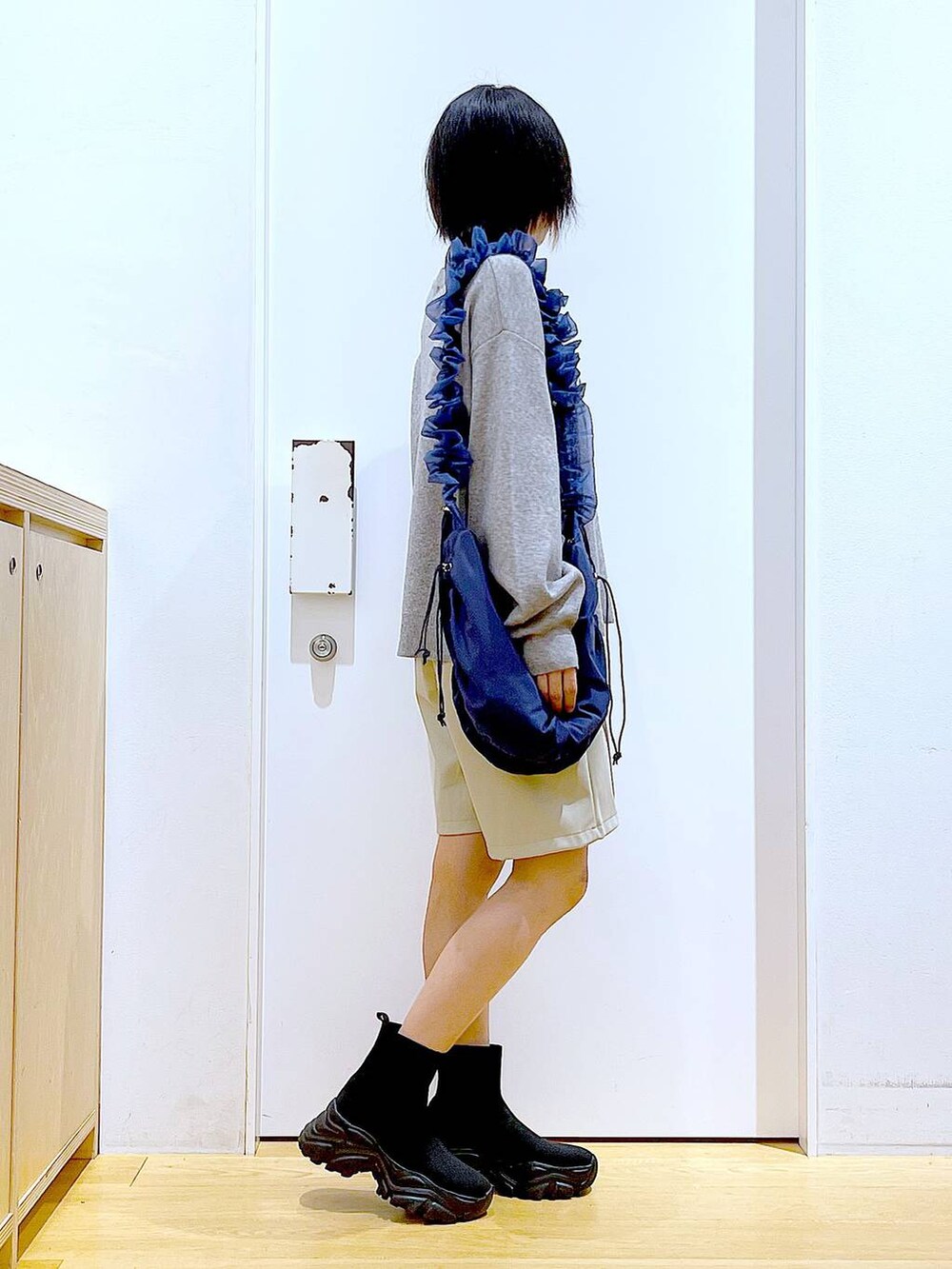 ブルー系のショルダーバッグ、ブラック系のブーツ、ベージュ系のその他パンツを着用したレディースの冬コーディネートの4枚目の写真