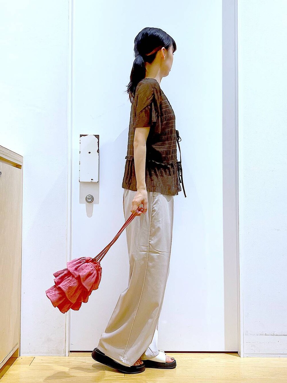 ホワイト系のサンダル、ベージュ系のスラックス、ピンク系のショルダーバッグを着用したレディースの秋コーディネートの4枚目の写真