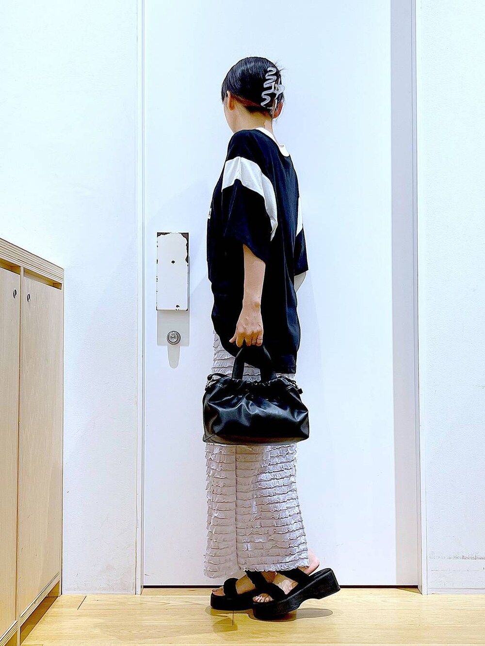 ブラック系のサンダル、ブラック系のショルダーバッグ、ブラック系のTシャツ/カットソーを着用したレディースの夏コーディネートの3枚目の写真