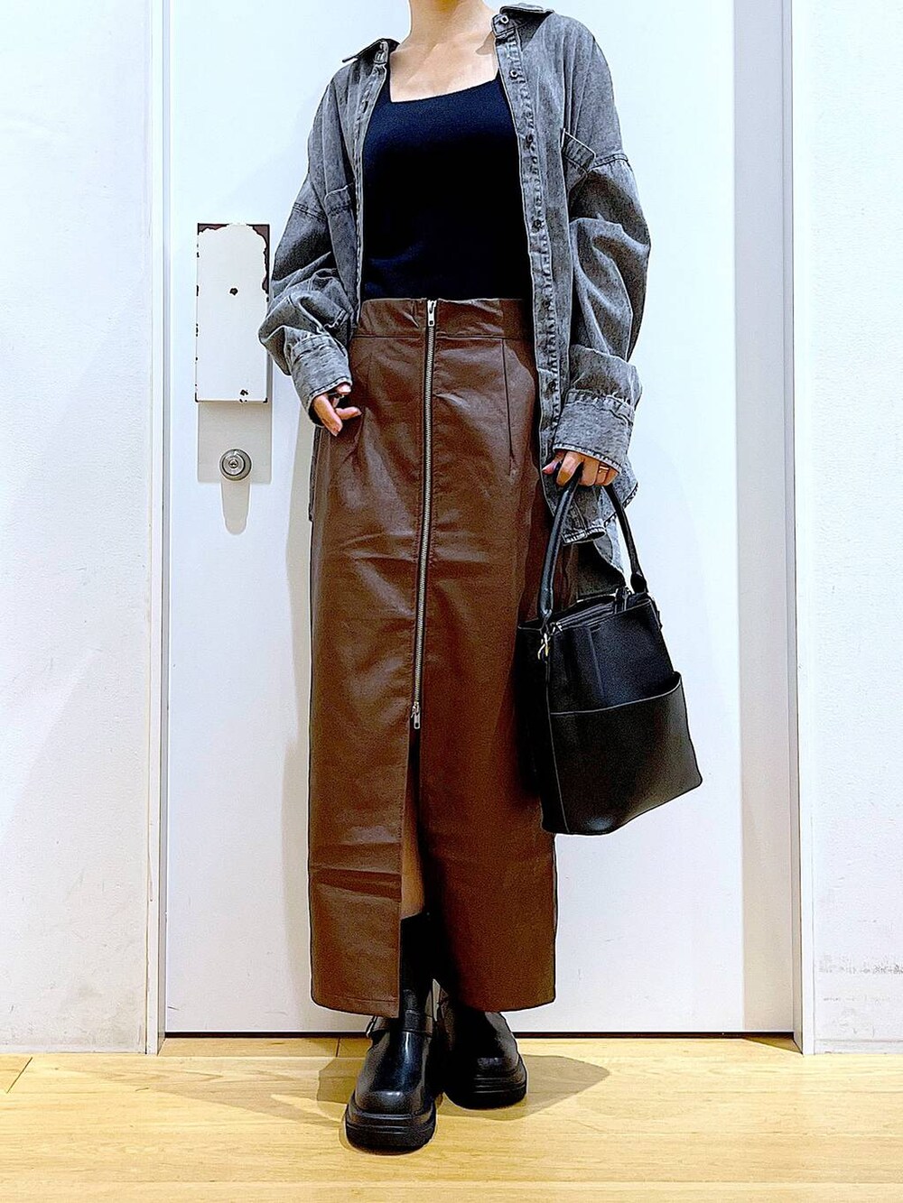 ブラウン系のスカート、ブラック系のニット/セーター、ブラック系のショルダーバッグを着用したレディースの秋コーディネートの6枚目の写真