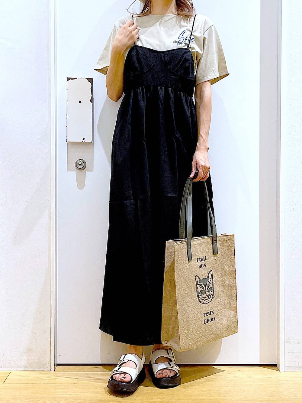 ホワイト系のサンダル、グレー系のトートバッグ、ブラック系のワンピースを着用したレディースの夏コーディネートの6枚目の写真