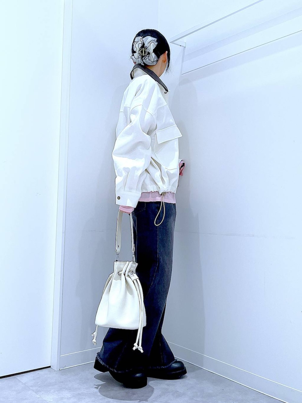 ピンク系のTシャツ/カットソー、ブラック系のデニムパンツ、ホワイト系のショルダーバッグを着用したレディースの春コーディネートの4枚目の写真