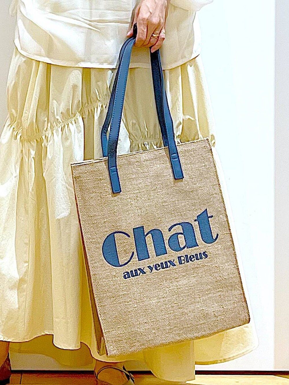 その他のパンプス、ブルー系のトートバッグ、ベージュ系のその他トップスを着用したレディースの春コーディネートの9枚目の写真