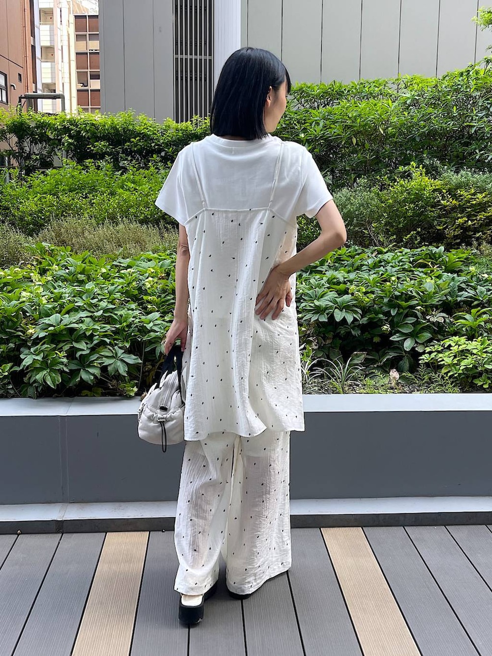 ホワイト系のサンダル、ホワイト系のTシャツ/カットソー、ホワイト系のショルダーバッグを着用したレディースの夏コーディネートの4枚目の写真