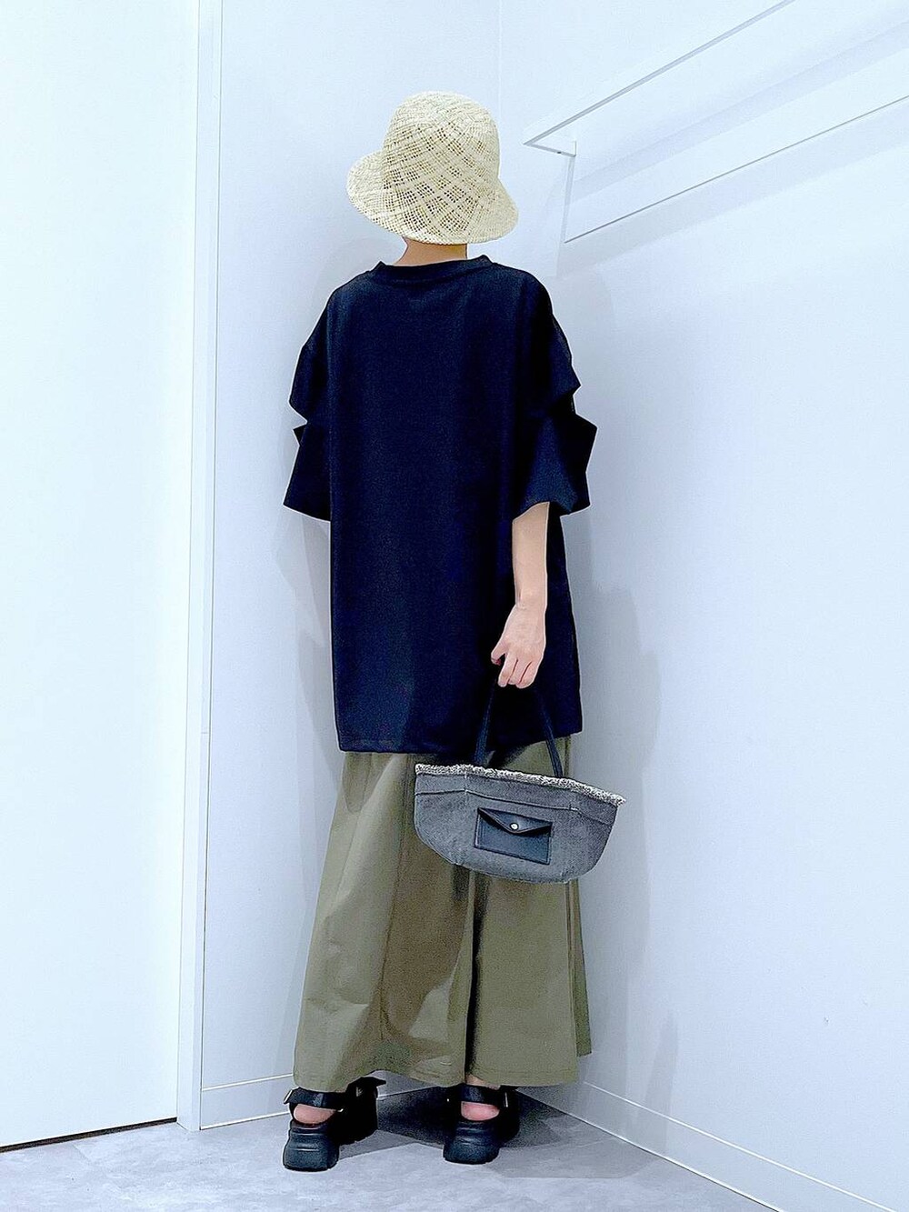 ブラック系のショルダーバッグ、ブラック系のサンダル、グリーン系のスカートを着用したレディースの夏コーディネートの5枚目の写真