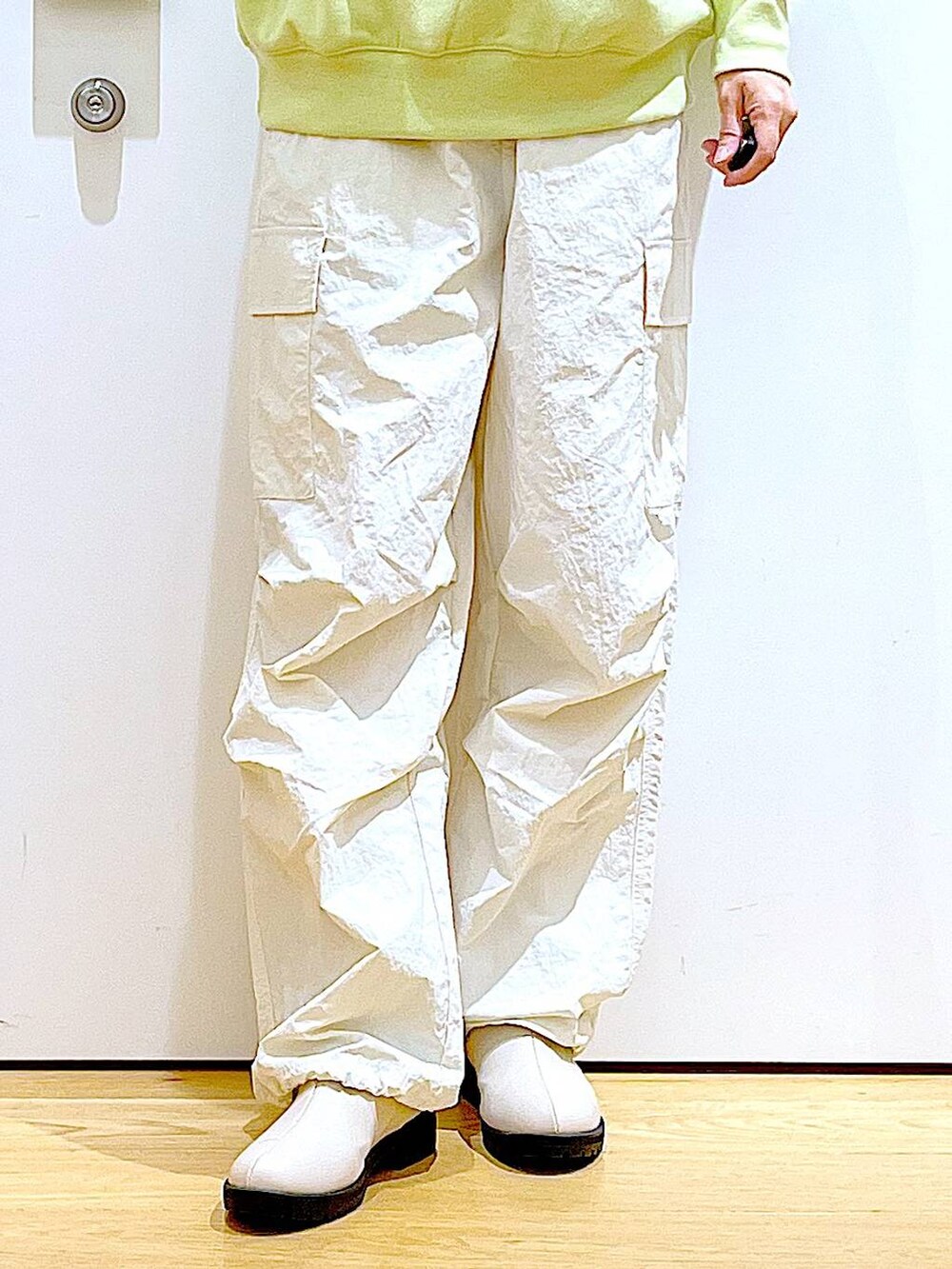 イエロー系のスウェット、ベージュ系のブーツ、その他のショルダーバッグを着用したレディースの春コーディネートの8枚目の写真