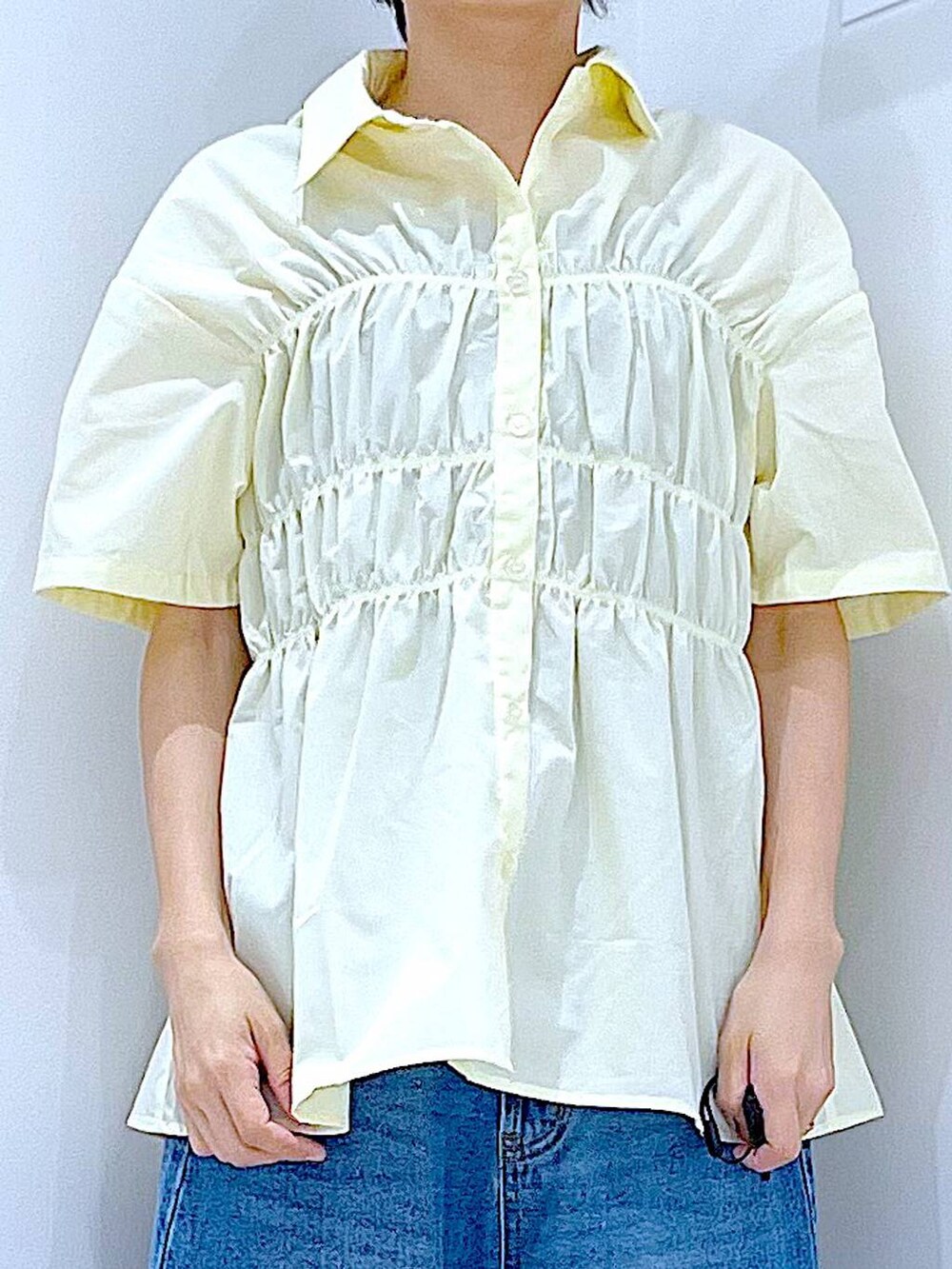 ブルー系のデニムパンツ、ベージュ系のショルダーバッグ、シルバー系のサンダルを着用したレディースの夏コーディネートの7枚目の写真