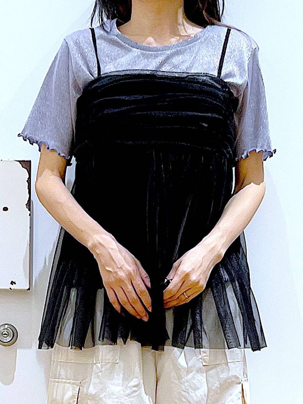 ブラック系のショルダーバッグ、ホワイト系のカーゴパンツ、ブラック系のキャミソールを着用したレディースの夏コーディネートの7枚目の写真