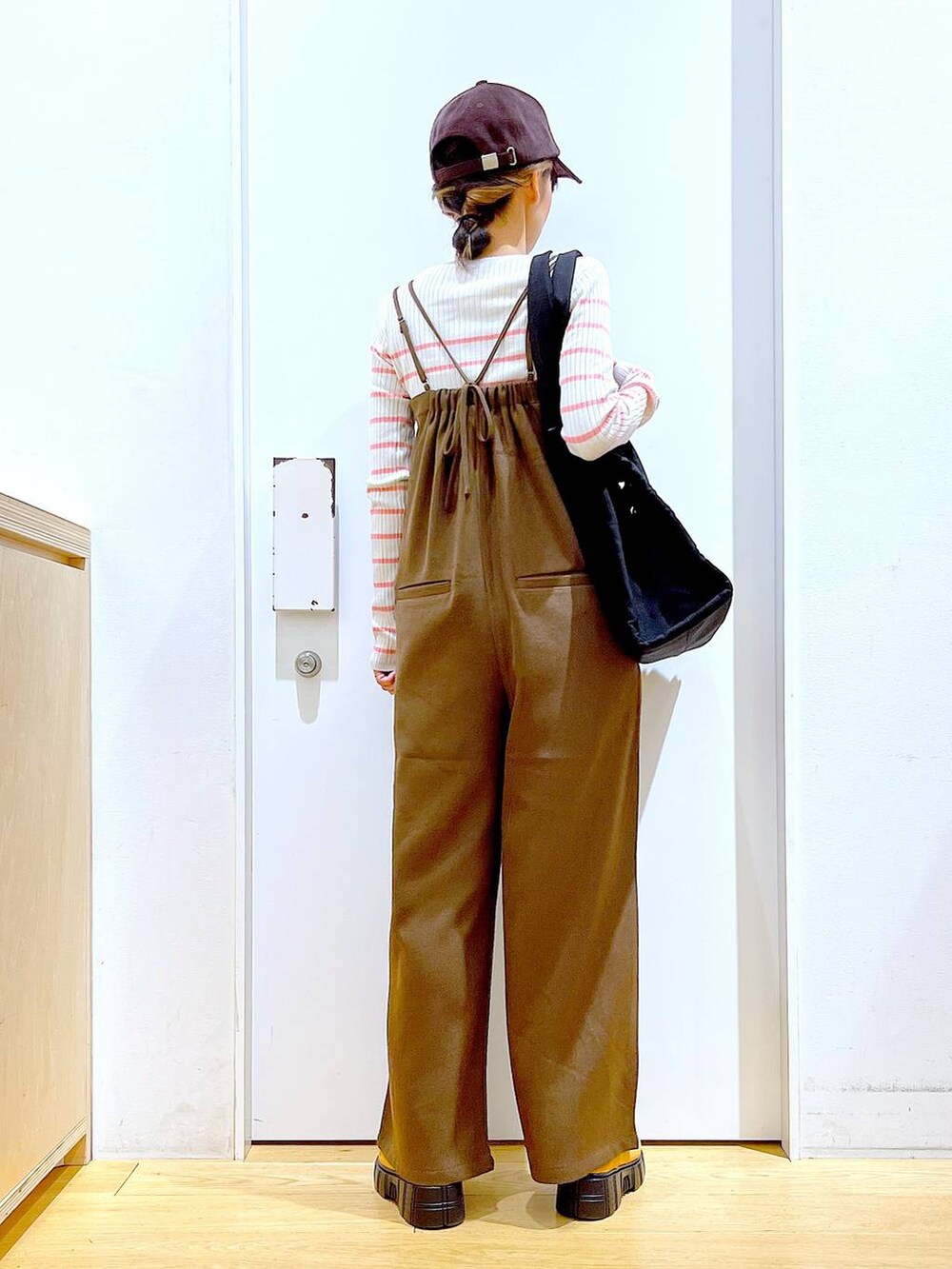 ピンク系のニット/セーター、ブラック系のショルダーバッグ、ベージュ系のブーツを着用したレディースの冬コーディネートの5枚目の写真