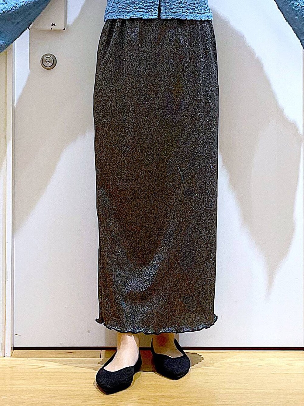 ブラック系のスカート、ブラック系のショルダーバッグ、ブラック系のパンプスを着用したレディースの春コーディネートの8枚目の写真