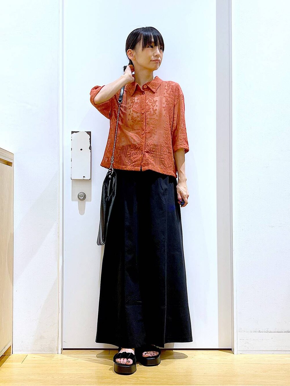 ブラック系のショルダーバッグ、レッド系のシャツ/ブラウス、ブラック系のスカートを着用したレディースの夏コーディネートの2枚目の写真