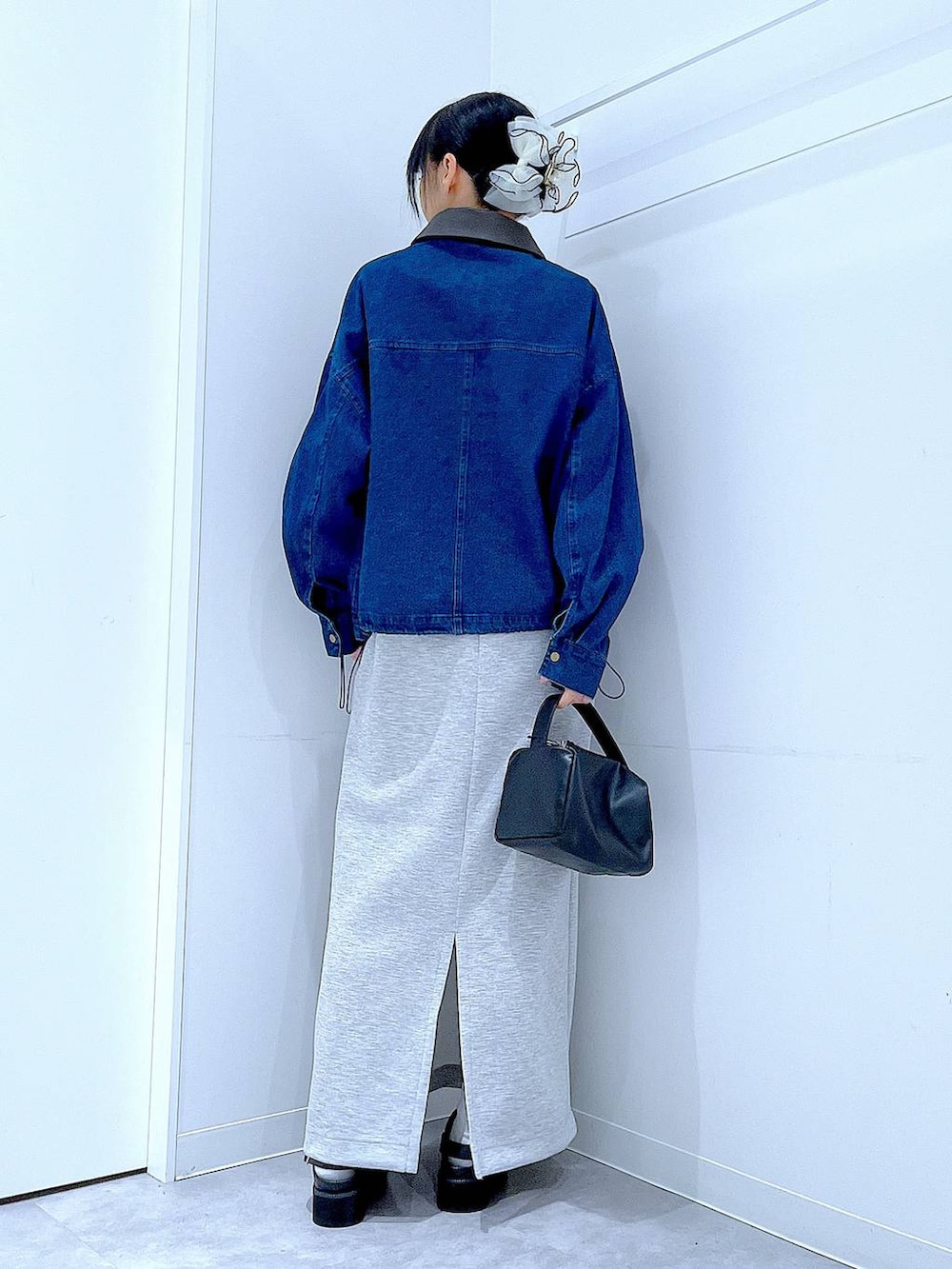 ブラック系のショルダーバッグ、グレー系のスカート、ブラック系のサンダルを着用したレディースの春コーディネートの5枚目の写真