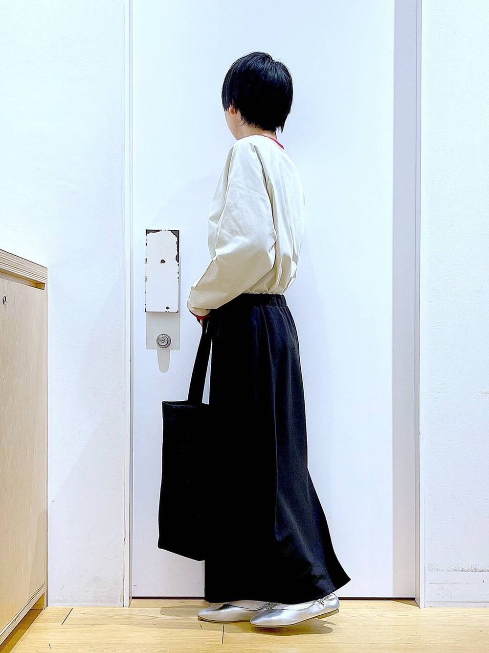 ブラック系のトートバッグ、シルバー系のパンプス、ブラック系のスカートを着用したレディースの春コーディネートの3枚目の写真