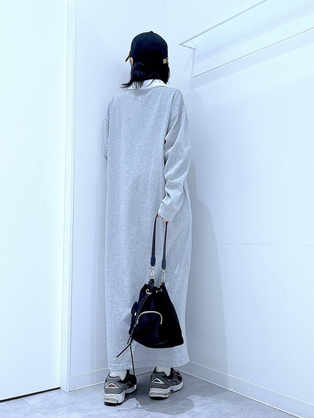 ブラック系のショルダーバッグ、グレー系のワンピース、ブラック系のキャップを着用したレディースの春コーディネートの5枚目の写真