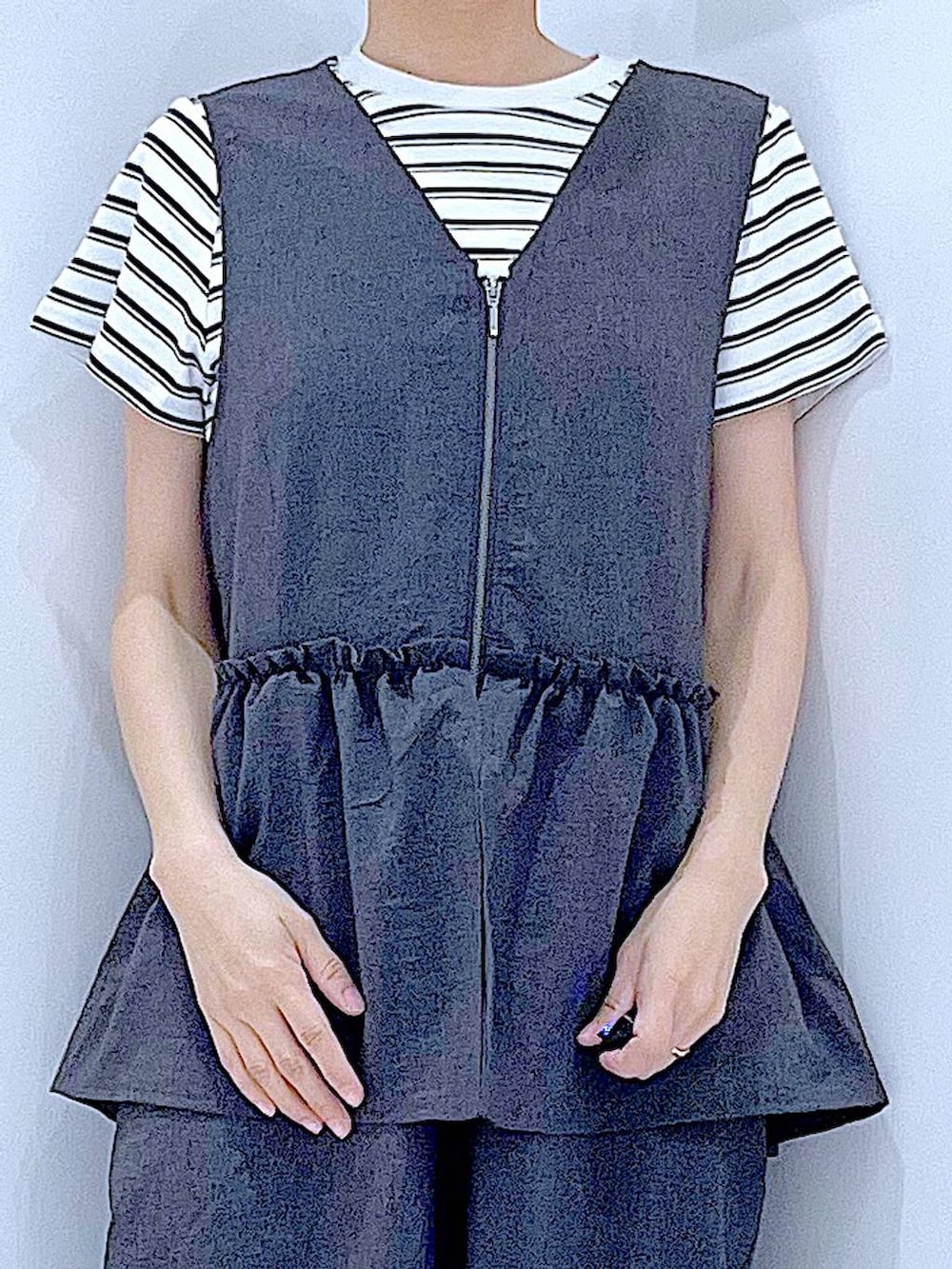 ベージュ系のショルダーバッグ、ブラック系のサンダル、ベージュ系のTシャツ/カットソーを着用したレディースの夏コーディネートの7枚目の写真