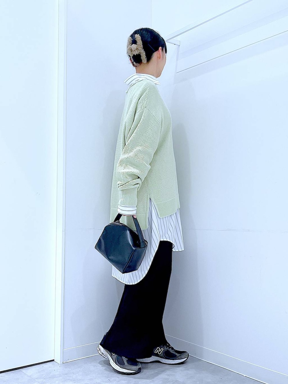 ブラック系のショルダーバッグ、ホワイト系のシャツ/ブラウス、グリーン系のニット/セーターを着用したレディースの春コーディネートの4枚目の写真