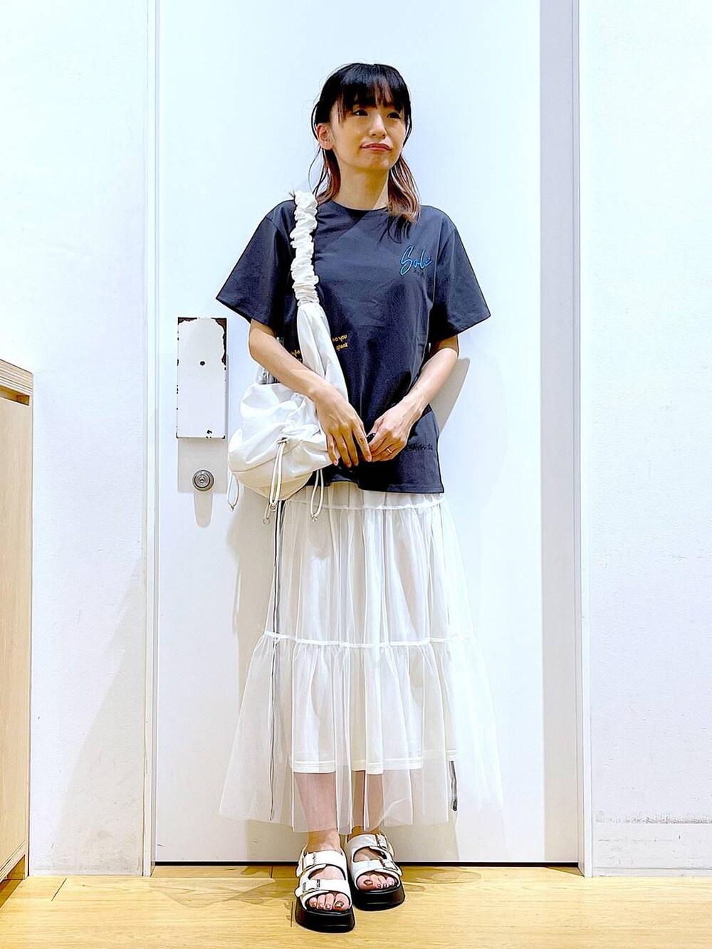 ホワイト系のサンダル、ホワイト系のショルダーバッグ、ホワイト系のスカートを着用したレディースの夏コーディネートの2枚目の写真