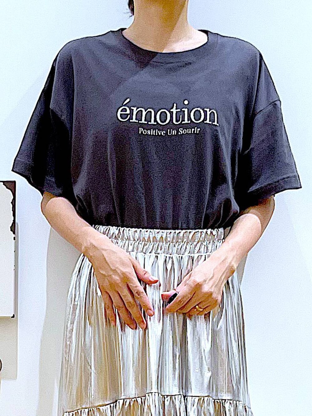 ブラック系のサンダル、シルバー系のスカート、ブルー系のトートバッグを着用したレディースの夏コーディネートの7枚目の写真