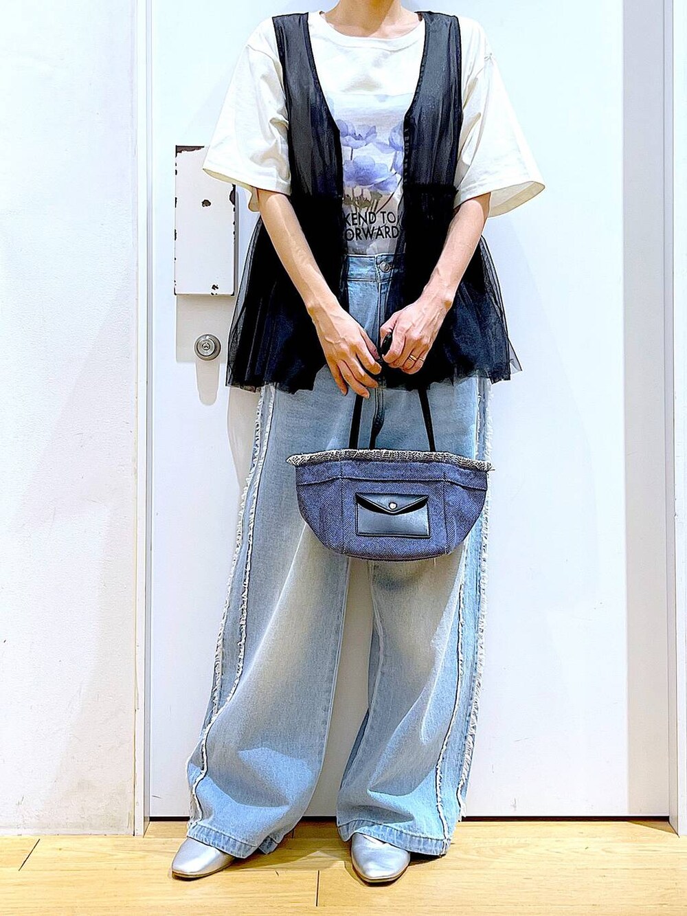 シルバー系のパンプス、ブルー系のショルダーバッグ、ブルー系のデニムパンツを着用したレディースの春コーディネートの6枚目の写真