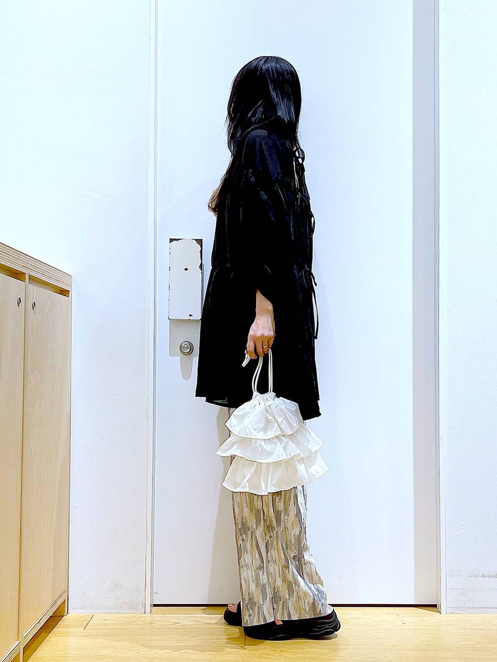 ホワイト系のショルダーバッグ、ブラック系のサンダル、ベージュ系のその他パンツを着用したレディースの夏コーディネートの3枚目の写真