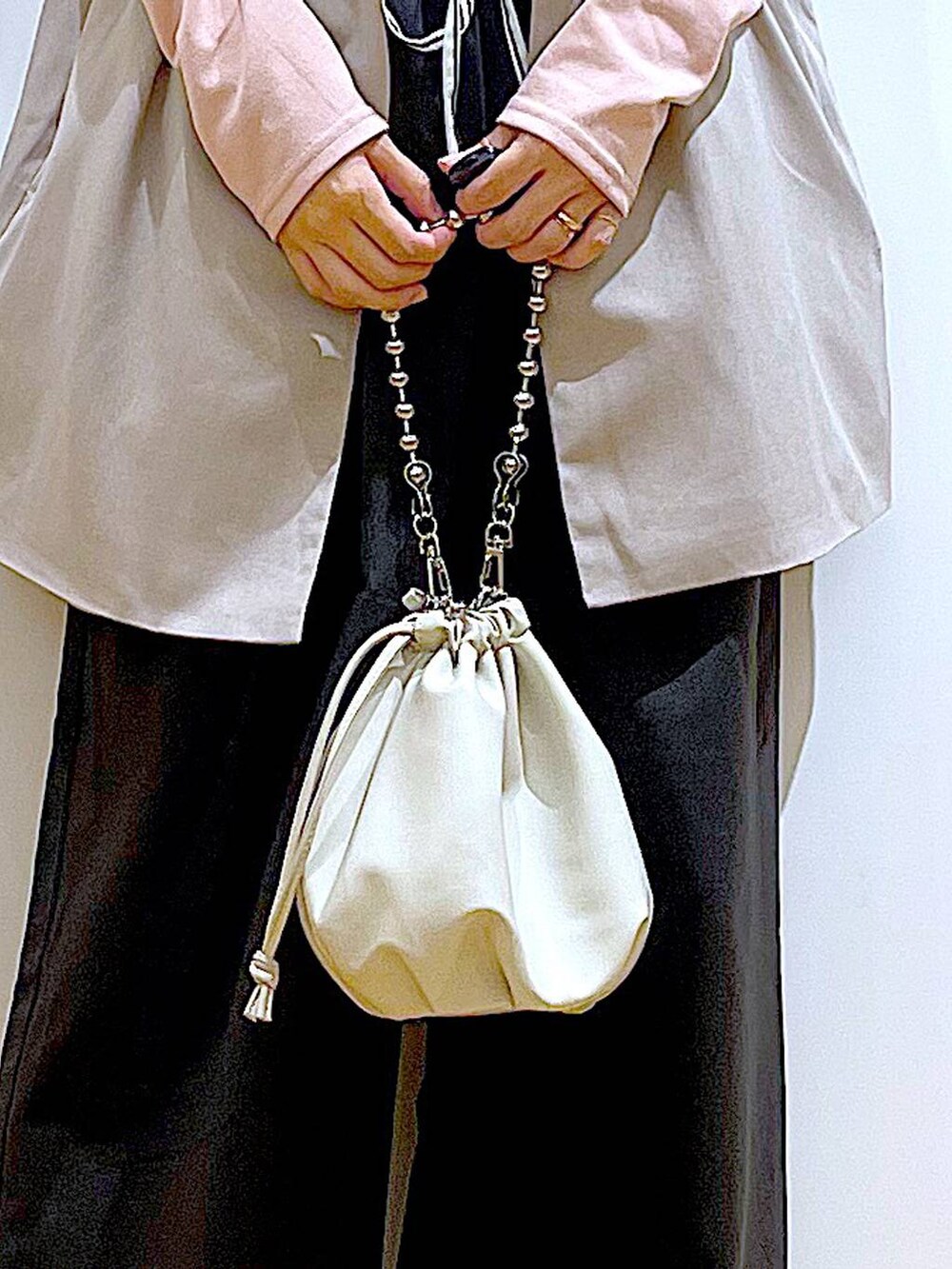 ベージュ系のショルダーバッグ、ブラック系のパンプス、ベージュ系のベストを着用したレディースの秋コーディネートの9枚目の写真