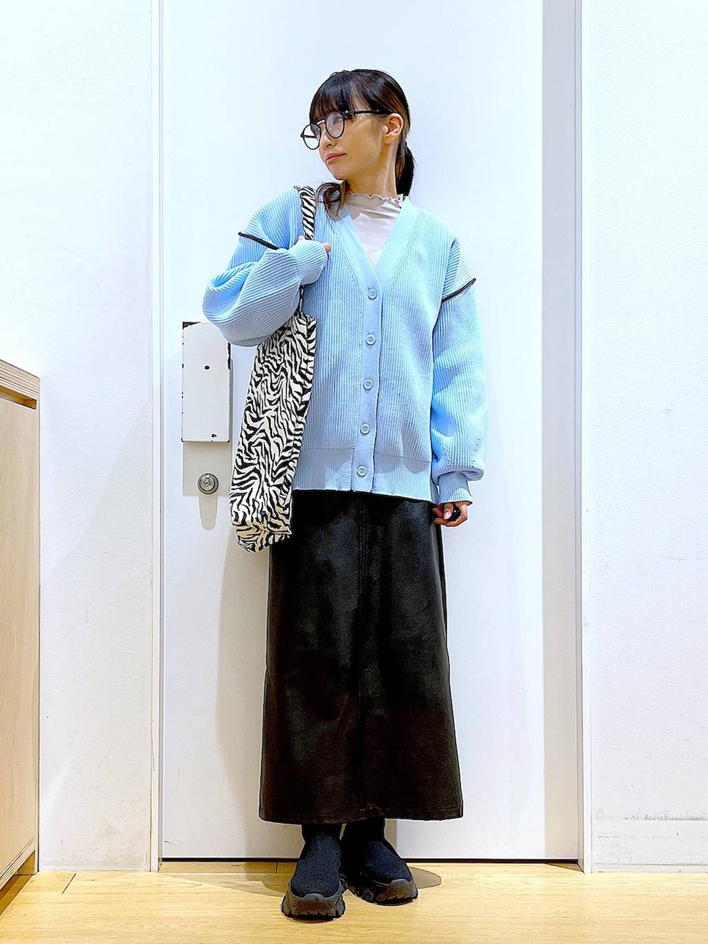 グレー系のTシャツ/カットソー、ブラック系のブーツ、その他のトートバッグを着用したレディースの春コーディネートの2枚目の写真