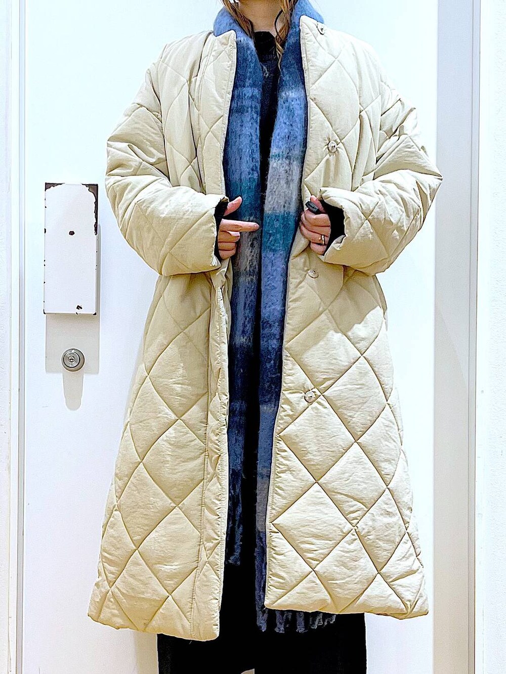 ブラック系のショルダーバッグ、ブラック系のブーツ、ベージュ系のノーカラーコートを着用したレディースの冬コーディネートの7枚目の写真