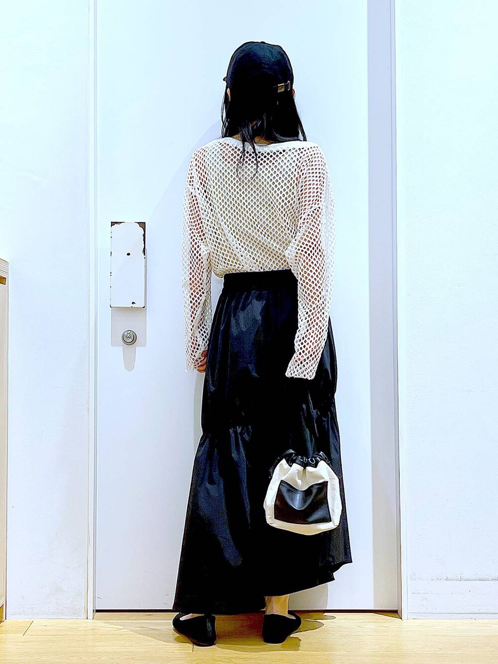 ホワイト系のTシャツ/カットソー、ホワイト系のショルダーバッグ、イエロー系のニット/セーターを着用したレディースの春コーディネートの5枚目の写真