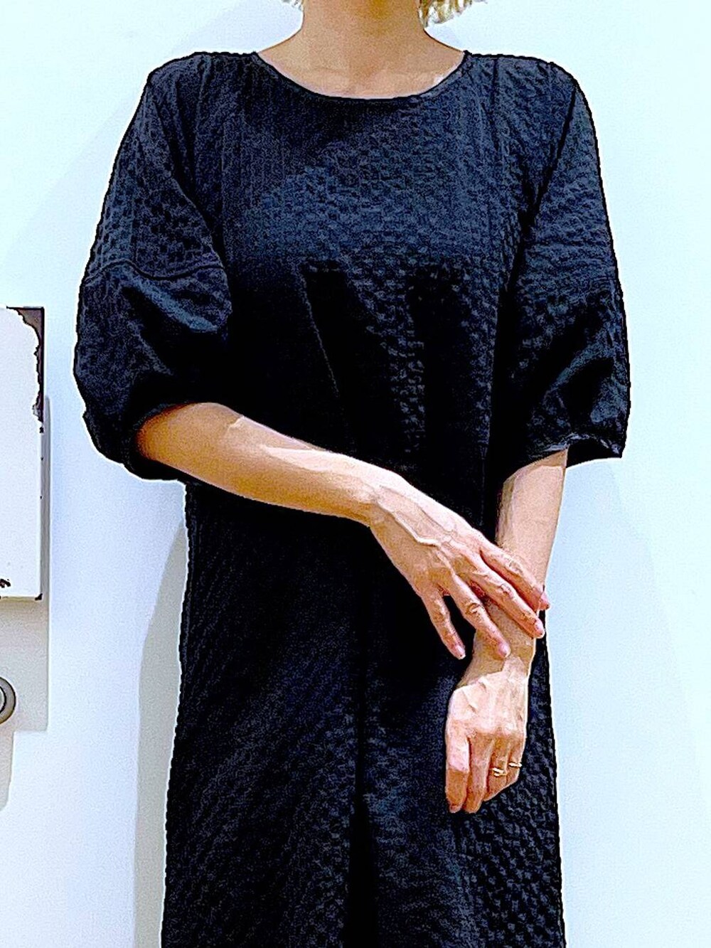 ホワイト系のパンプス、ブラック系のショルダーバッグ、ブラック系のワンピースを着用したレディースの夏コーディネートの7枚目の写真