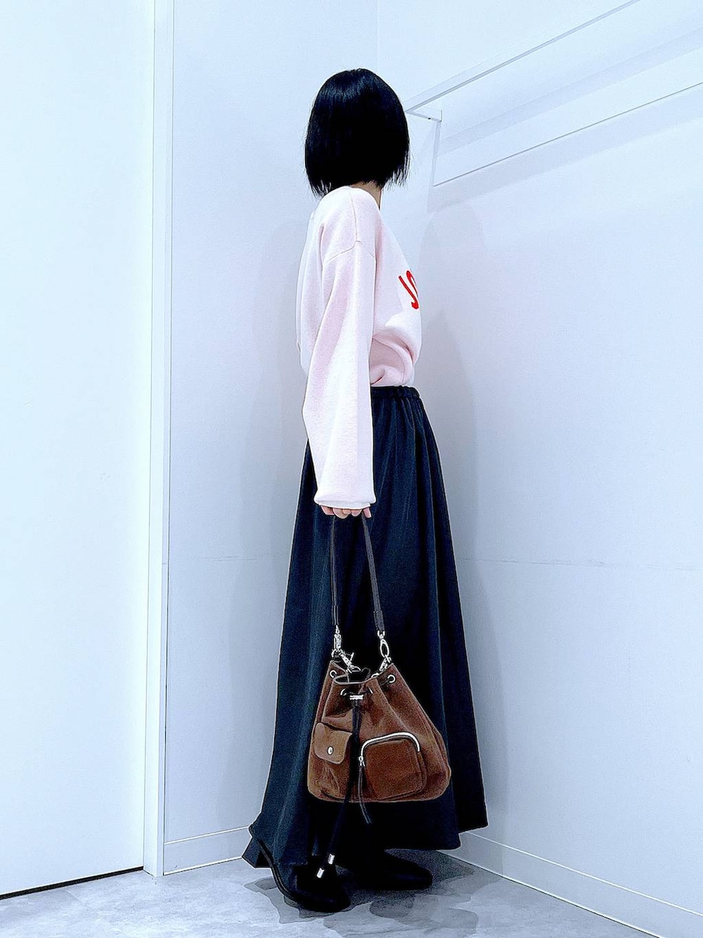 ブラウン系のショルダーバッグ、ブラック系のブーツ、ベージュ系のニット/セーターを着用したレディースの冬コーディネートの4枚目の写真