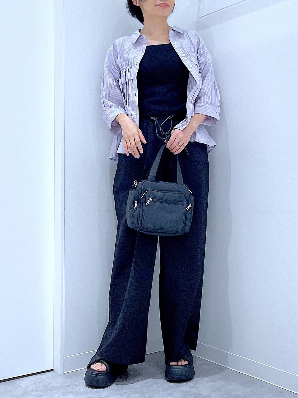 ブラック系のサンダル、ブラック系のその他パンツ、パープル系のシャツ/ブラウスを着用したレディースの夏コーディネートの6枚目の写真