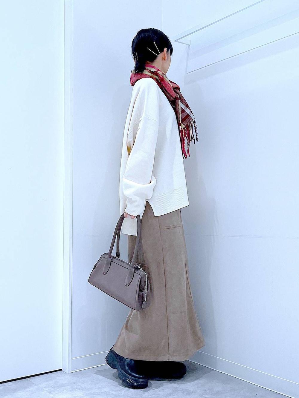 ブラック系のブーツ、ベージュ系のニット/セーター、ブラウン系のスカートを着用したレディースの秋コーディネートの4枚目の写真