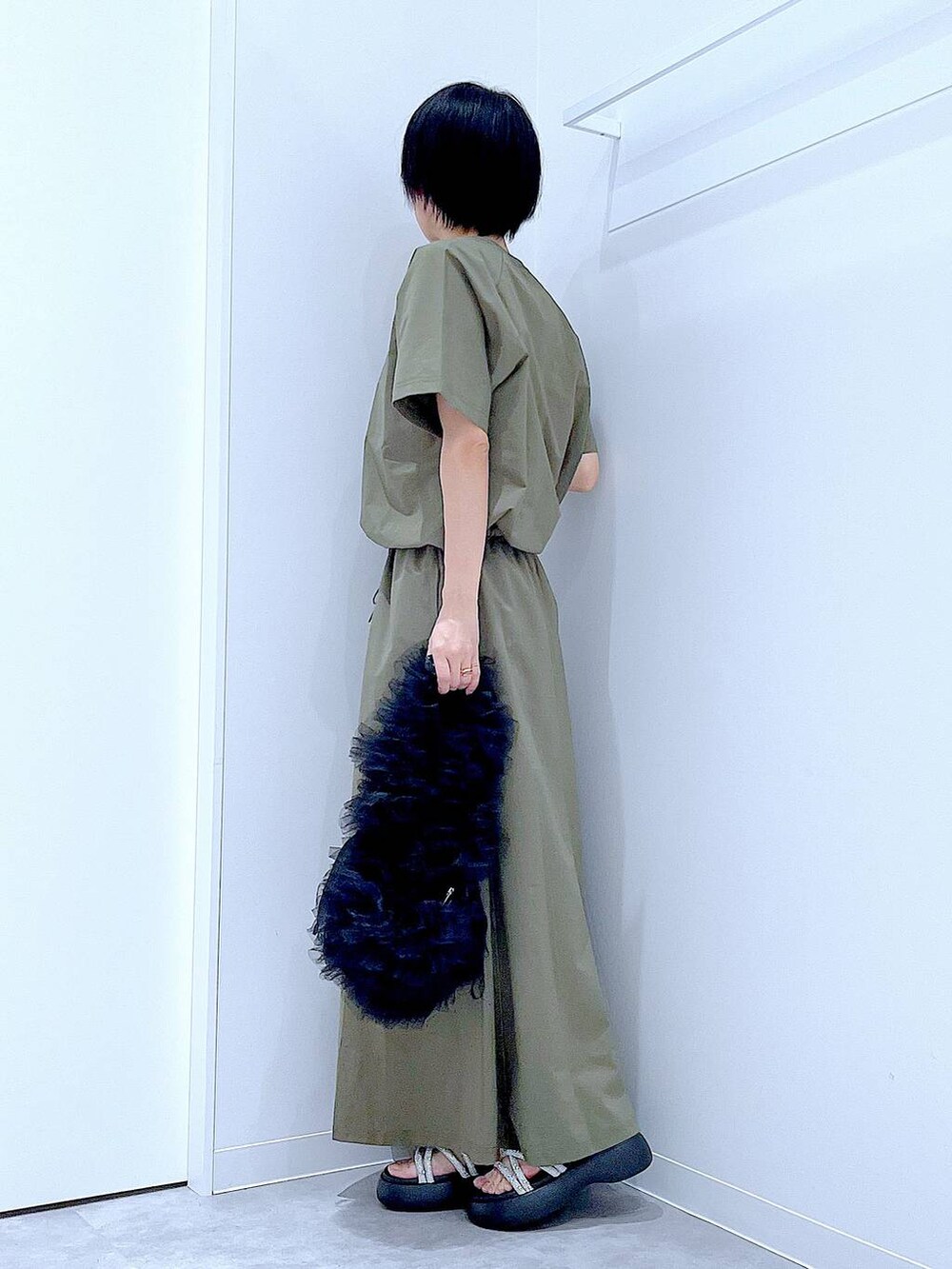 ブラック系のショルダーバッグ、シルバー系のサンダル、グリーン系のTシャツ/カットソーを着用したレディースの夏コーディネートの3枚目の写真