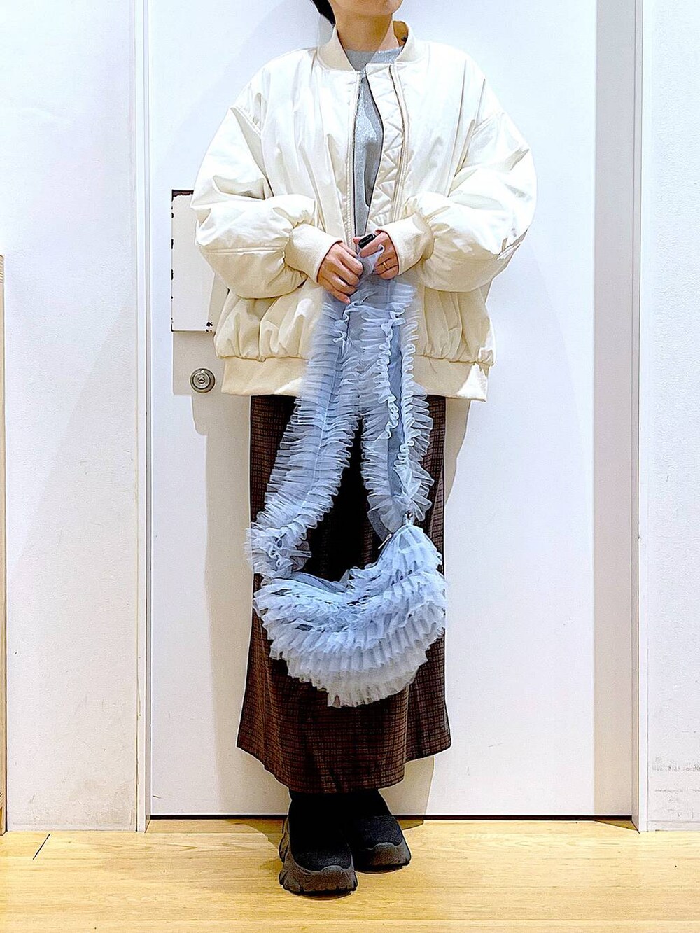 ブラック系のブーツ、グレー系のスウェット、ブラウン系のワンピースを着用したレディースの冬コーディネートの6枚目の写真