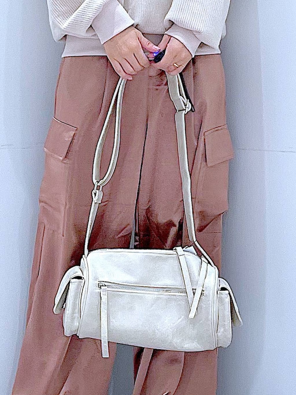 ブラック系のブーツ、ベージュ系のニット/セーター、ピンク系のカーゴパンツを着用したレディースの冬コーディネートの9枚目の写真