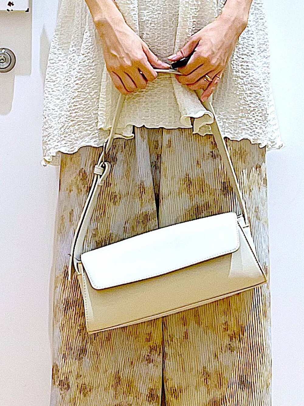 シルバー系のパンプス、ホワイト系のショルダーバッグ、ベージュ系のその他パンツを着用したレディースの春コーディネートの9枚目の写真