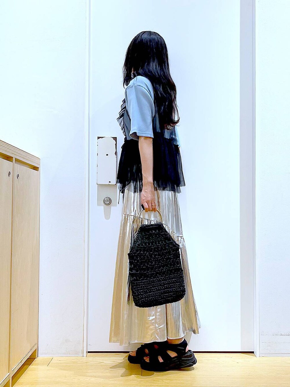 ブラック系のサンダル、ブルー系のTシャツ/カットソー、ブラック系のベストを着用したレディースの夏コーディネートの3枚目の写真