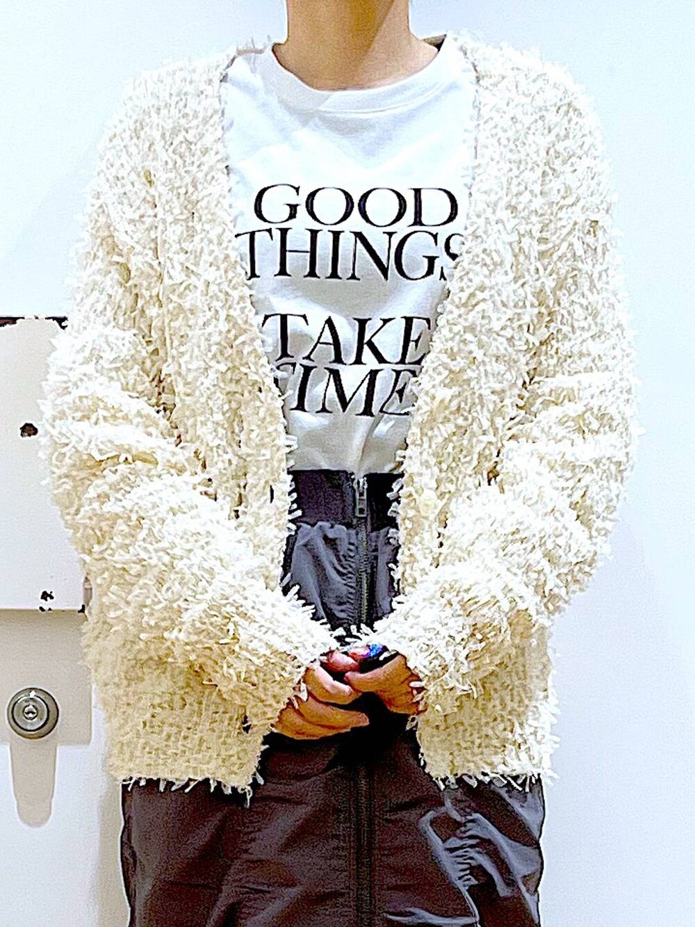 グレー系のスカート、ホワイト系のショルダーバッグ、ホワイト系のパンプスを着用したレディースの春コーディネートの7枚目の写真