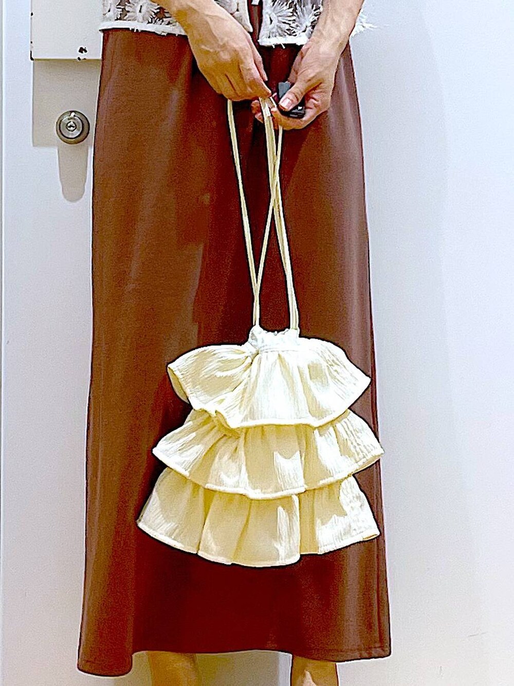 ホワイト系のサンダル、レッド系のワンピース、ホワイト系のベストを着用したレディースの夏コーディネートの9枚目の写真