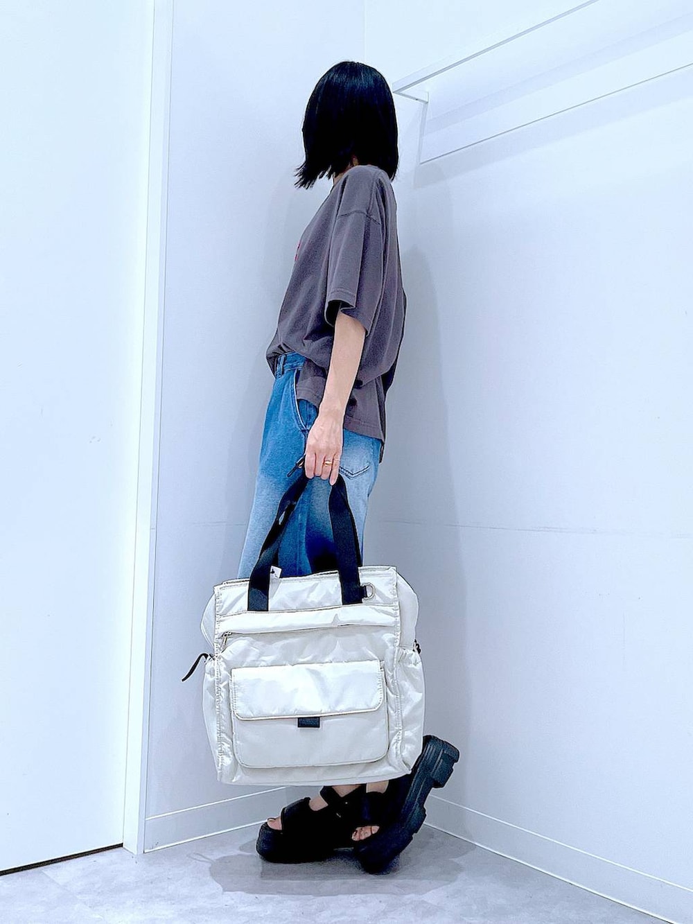 ブラック系のサンダル、ホワイト系のトートバッグ、グレー系のTシャツ/カットソーを着用したレディースの夏コーディネートの3枚目の写真