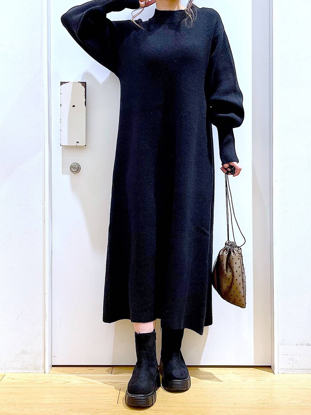 ブラック系のブーツ、ブラック系のワンピース、その他のポーチを着用したレディースの冬コーディネートの6枚目の写真