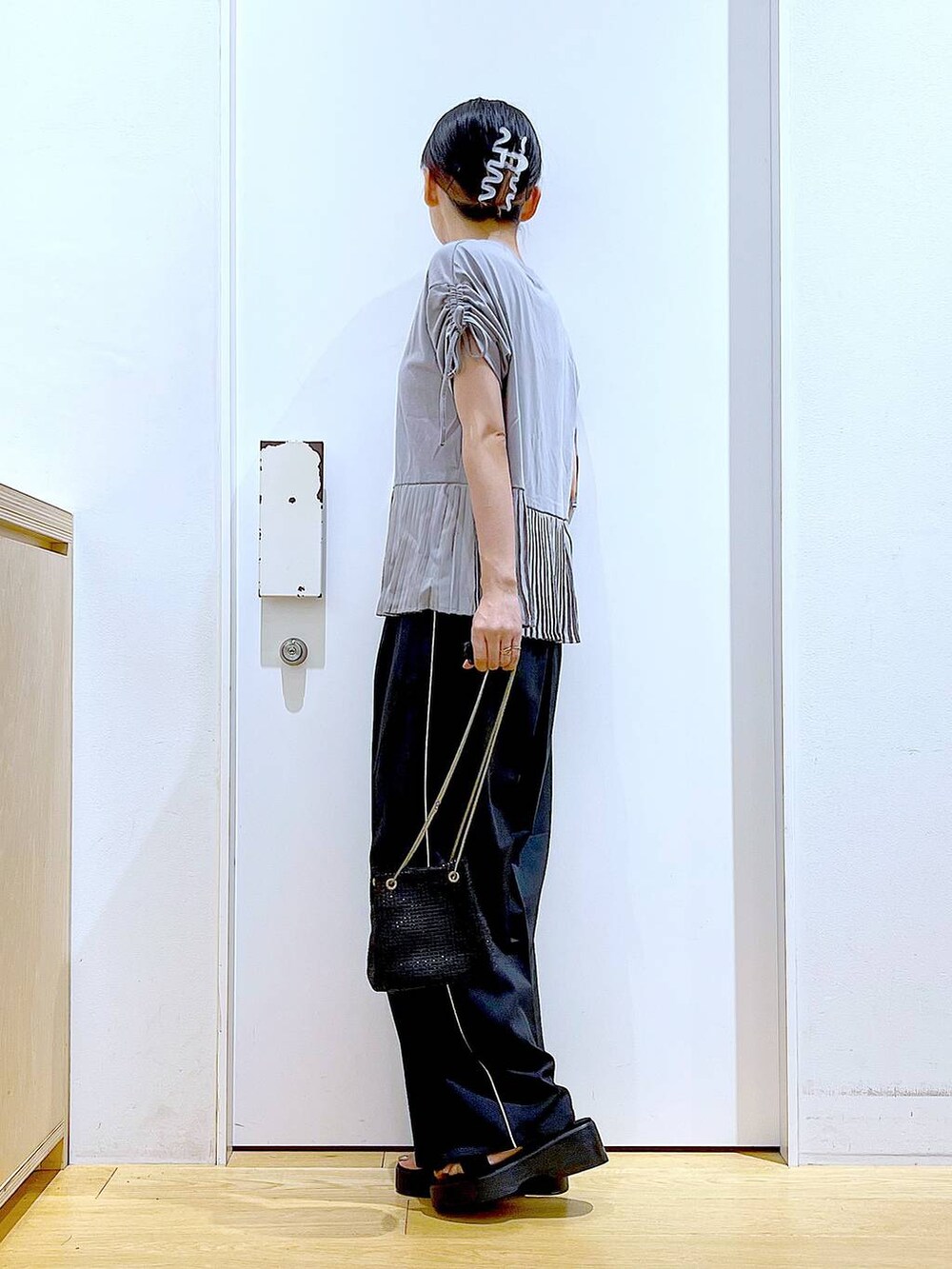 ブラック系のサンダル、ブラック系のスラックス、グレー系のTシャツ/カットソーを着用したレディースの秋コーディネートの3枚目の写真