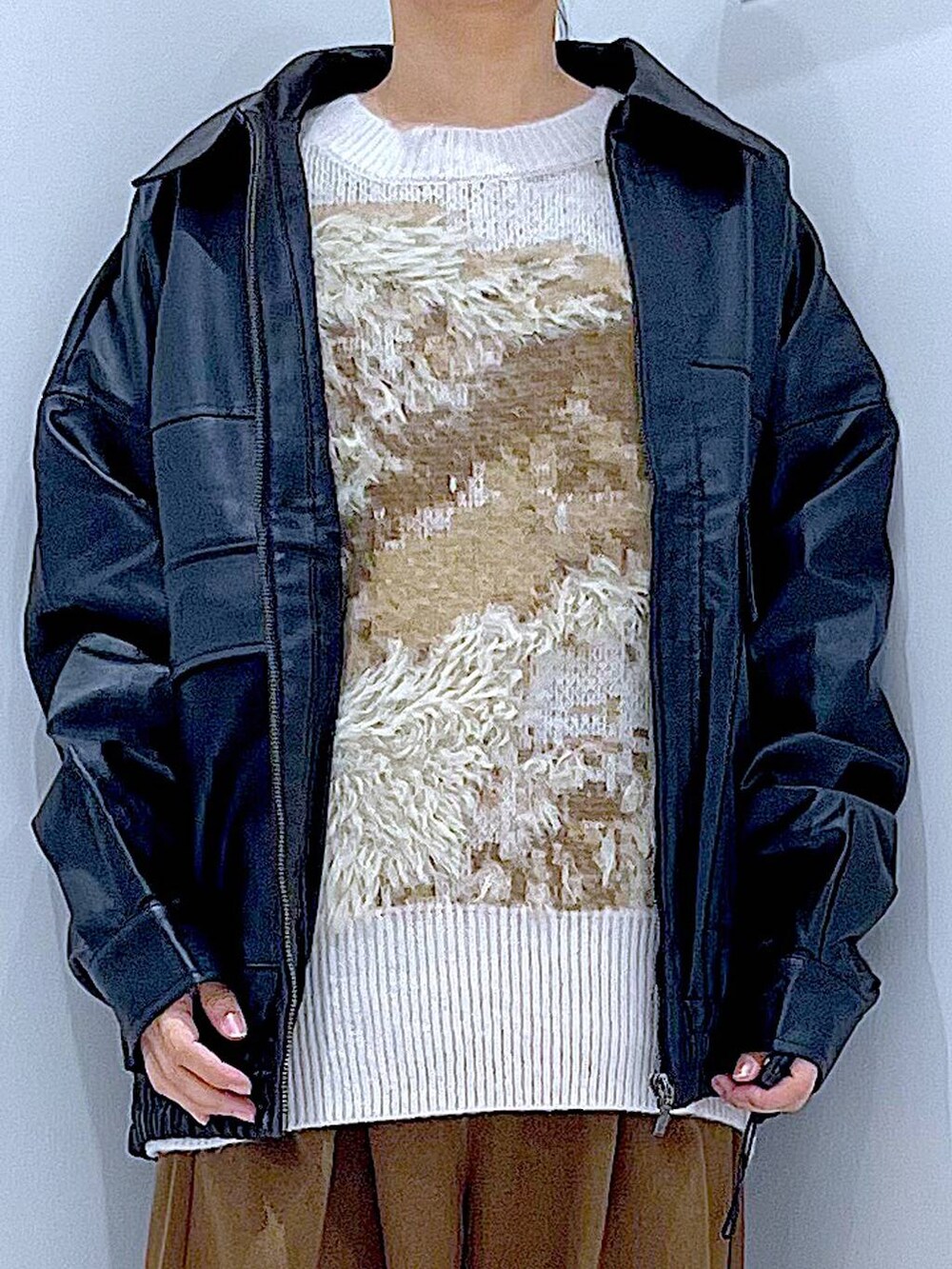 ブラック系のブルゾン、ブラック系のブーツ、ベージュ系のニット/セーターを着用したレディースの秋コーディネートの7枚目の写真